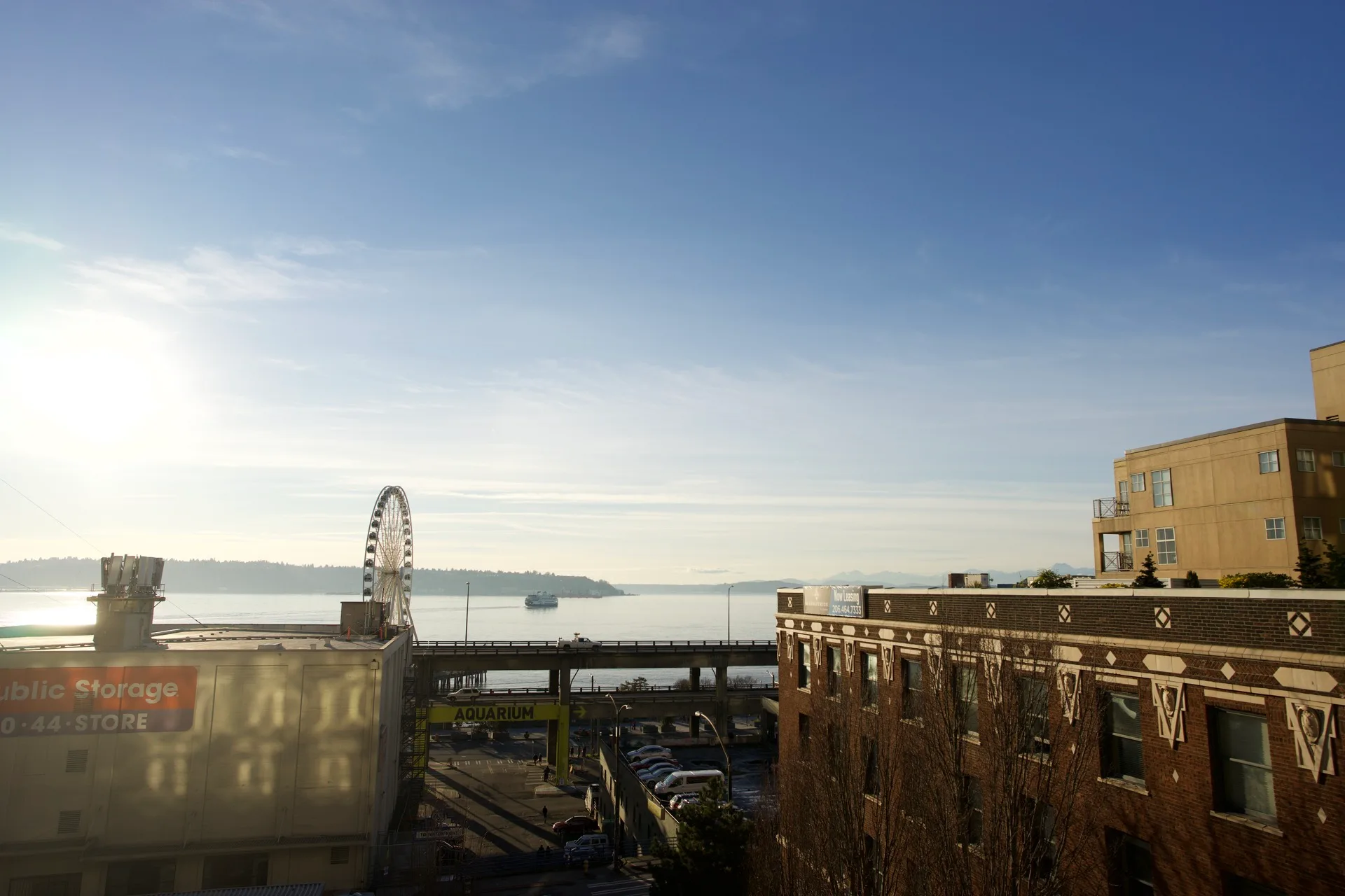 Elevated view of the Seattle waterfront with the Great Wheel, Alaskan Way Viaduct, Elliott Bay ferry in the distance, and old brick buildings in the foreground